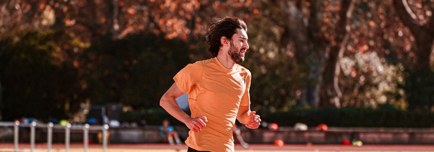Young Male Athlete Running in Stadium
