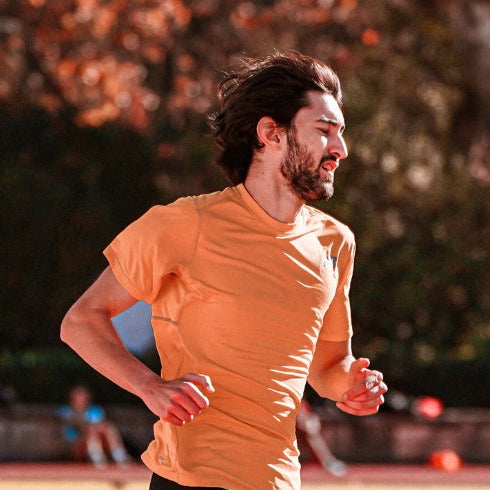 Young Male Athlete Running in Stadium