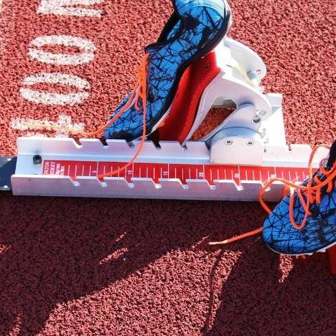 red starting blocks with shoes attached on a red track