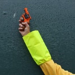 Arm of an athletics official wearing a hi-vis sleeve, holding an athletics starter pistol in the air