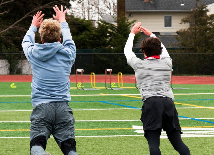 Two athletes practicing jumping