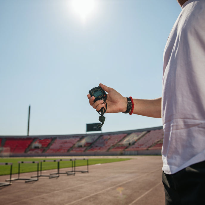 Athletics Official holding a stopwatch by a track