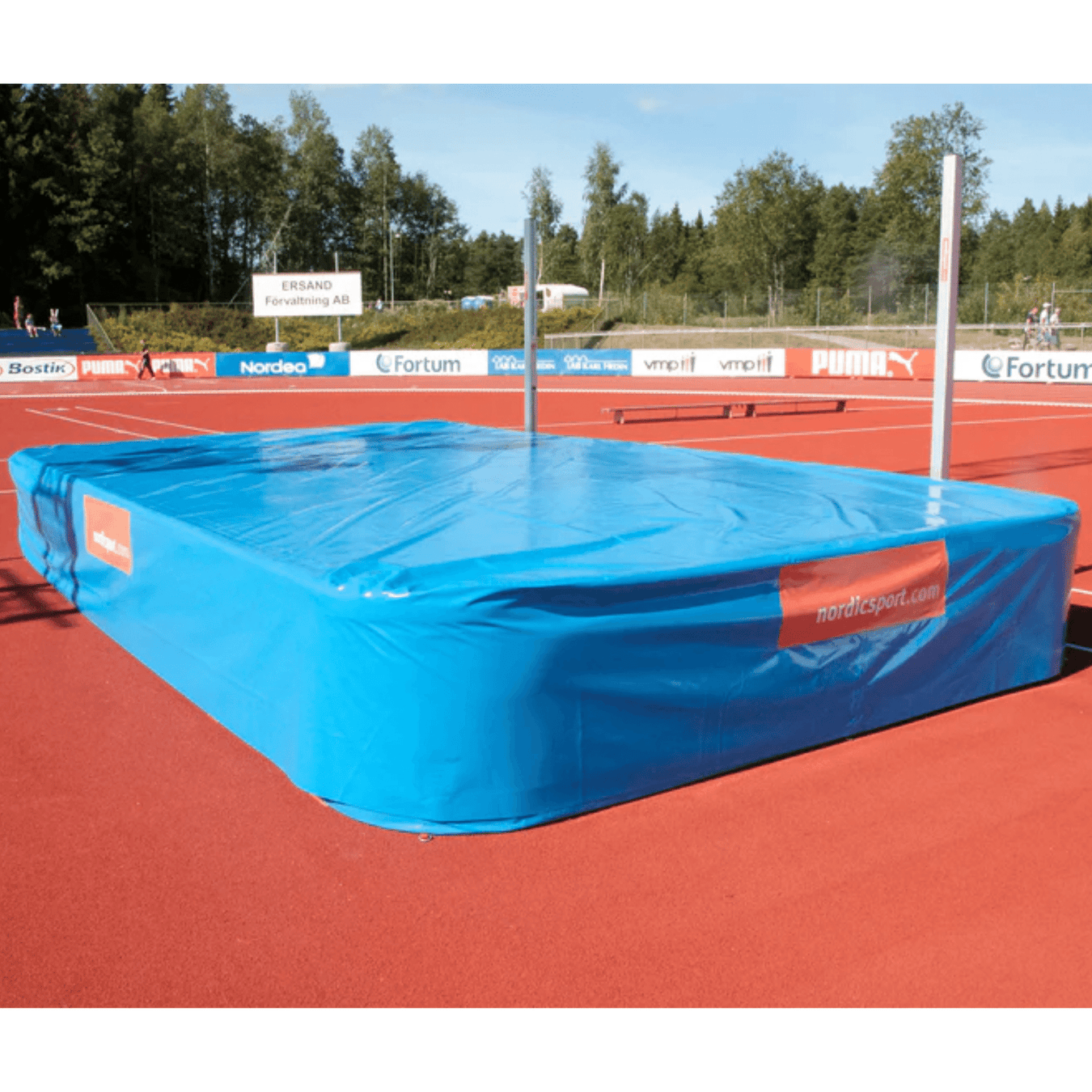 Nordic Sport High Jump Landing Area | Blue foam bed with an orange track background