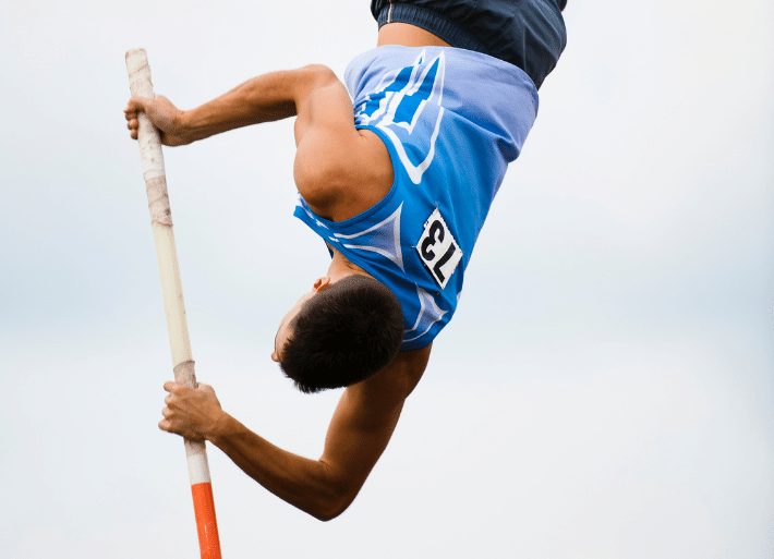 Pole Vaulter upside down on top of vaulting pole
