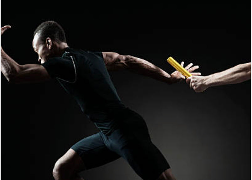 Athlete in black passing a yellow relay baton