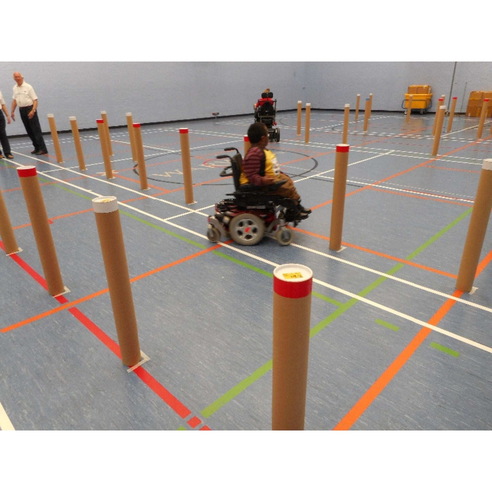 Person in a wheelchair navigating through a course with tubes marking out a slalom course