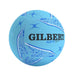 A light blue Gilbert APT netball with textured panels, blue graphic patterns, and black brand lettering, isolated on a white background.