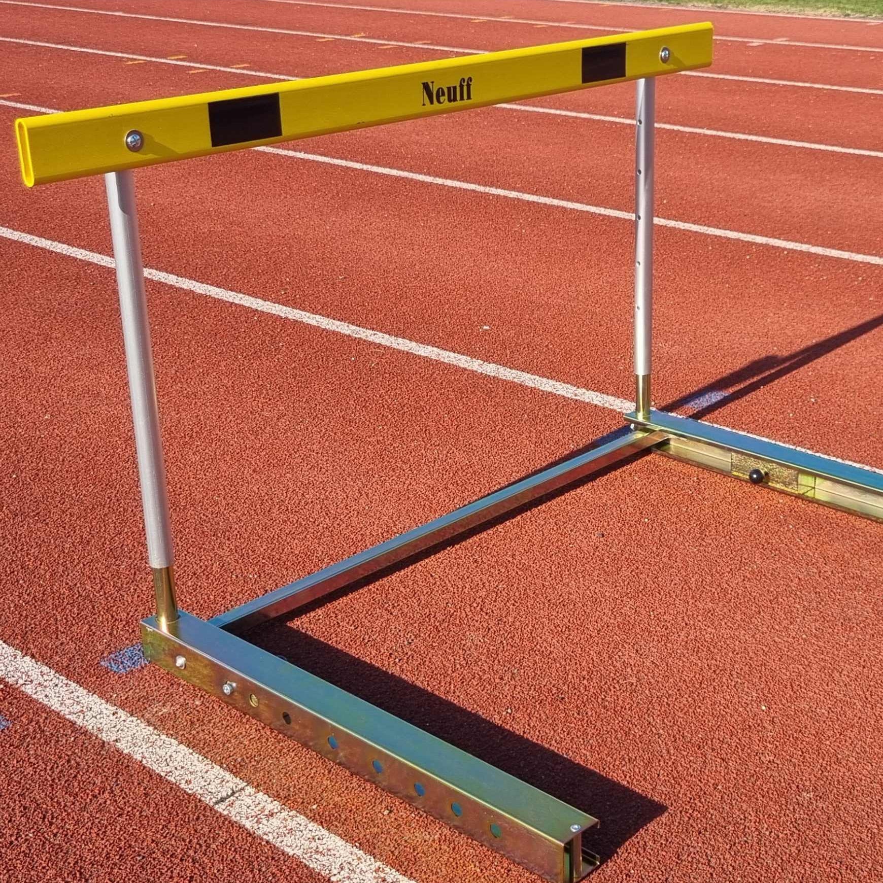 Yellow and silver hurdle with Neuff branding on a running track
