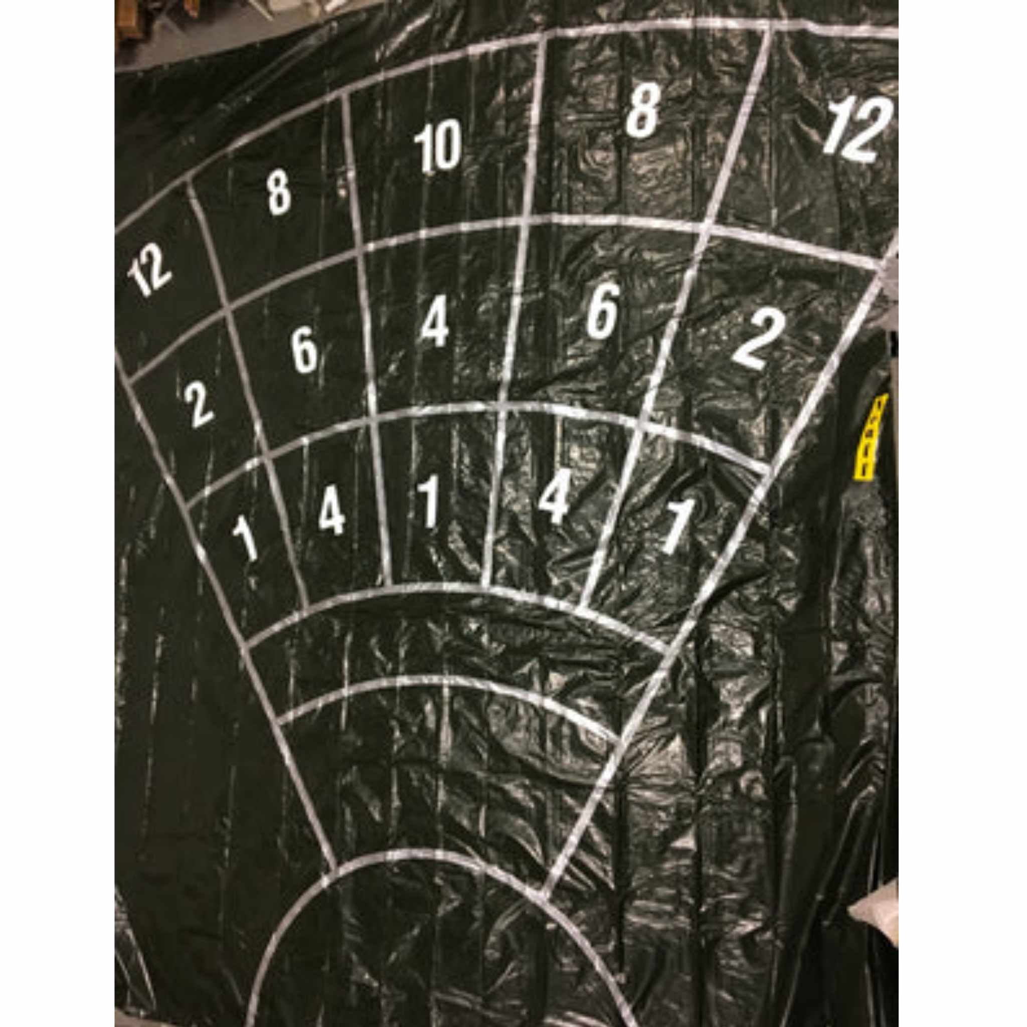 Black plastic sheet with white line segments and numbers in a grid style.  For precision target throwing for para athletes