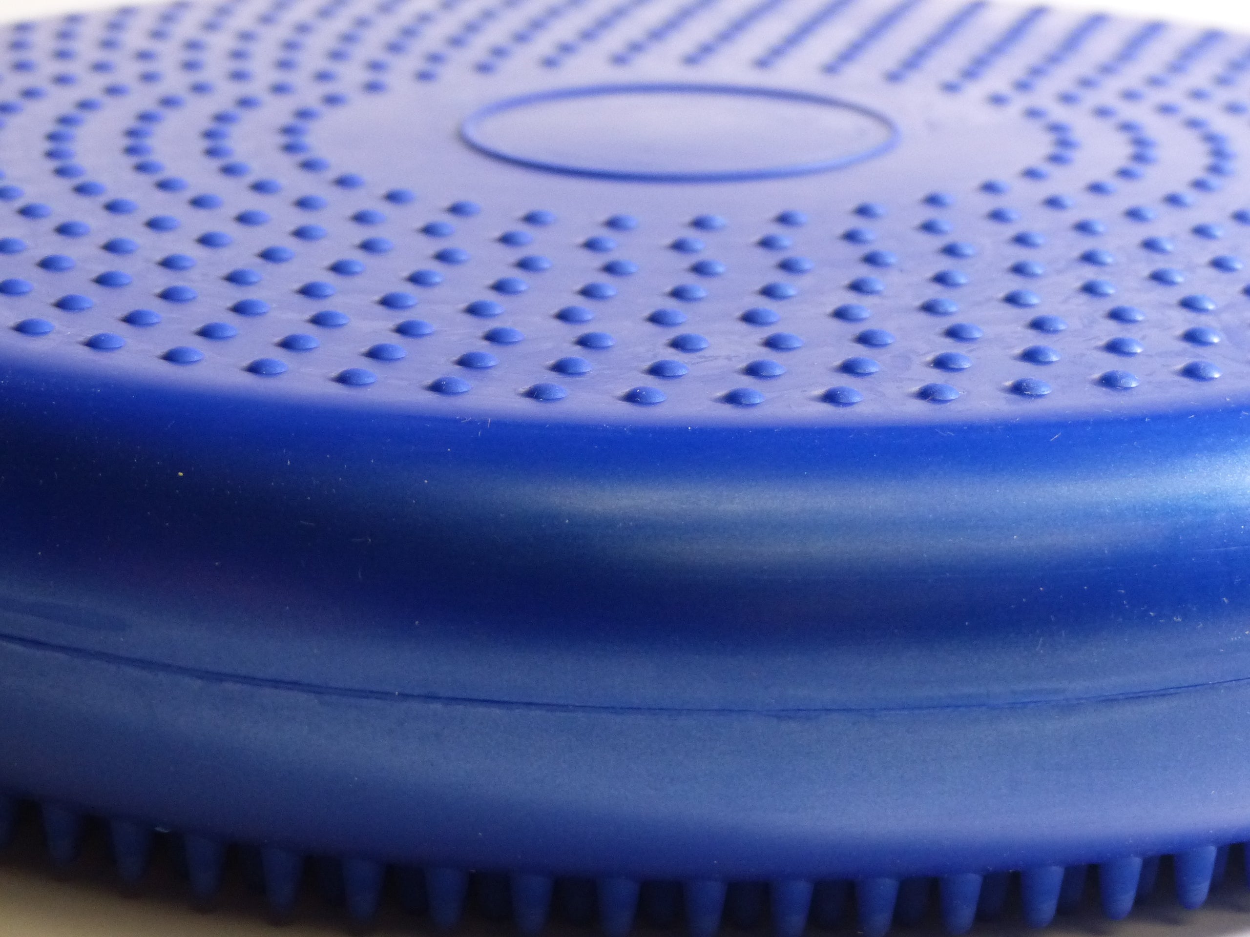 Round blue plastic cushion filled with air, with bumpy sides for grip and massage use. For standing on to improve balance, stability and core strength